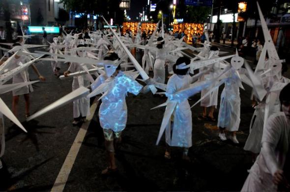 'Spring', 7 Bienal de Gwangju, Coreia do Sul, 2008. Procissão com 200 participantes com a duração de 90 minutos e desfile de 5 obras (5 grupos) realizadas por cinco artistas em conjunto com os estudantes da Universidade de Chosun. Na imagem trabalhos de Marlon Griffith (Trinidad) na frente e Mario Benjamin (Haiti) atrás. Foto de Akiko Ota