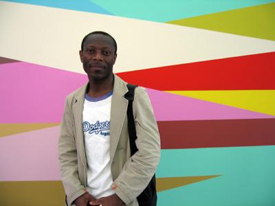 Olu Oguibe (atrás uma pintura mural de Odili Donald Odita). Foto de Christine Eyene.