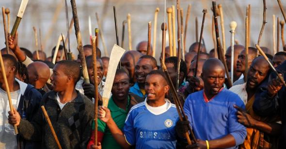 16 agosto 2012, mineiros em greve reúnem-se em área de mina da produtora de platina Lonmin, em Marikana, na África do Sul. A polícia abriu fogo contra os mineiros. 