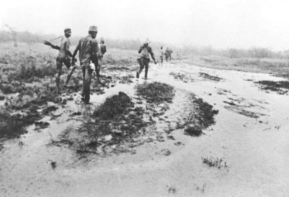 Guerrilheiros do PAIGC atravessando uma bolanha, interior da Guiné. 1963 - 1973