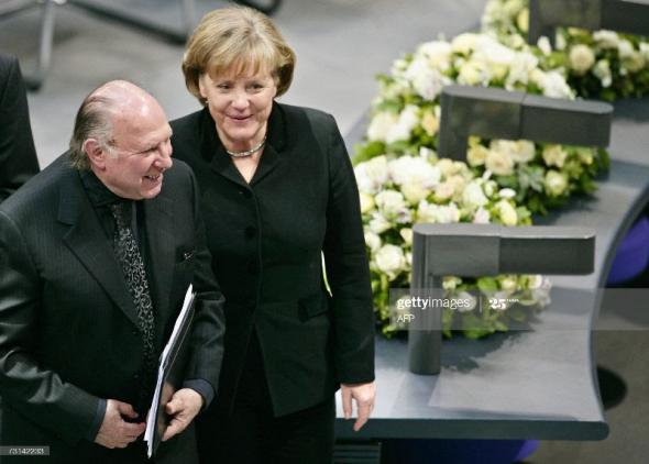 O escritor húngaro, Imre Kertész, prémio Nobel da literatura, com a chanceler alemã Angela Merkel| 2007 | Axel Schmidt/DDP/AFP via Getty Images