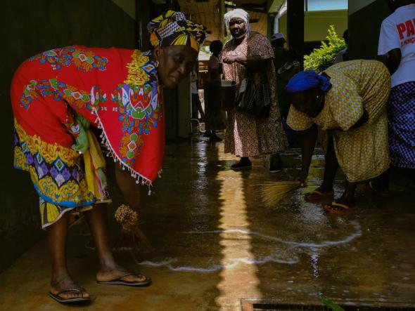 Fulacunda, Guinea Bissau (March 6, 2019) – Joana Gomes (center) instructs women cleaning the local hospital in Fulacunda, Guinea Bissau. Gomes, who was a medic on the frontlines during the independence war, donated beds to the hospital as part of her campaign. Image credit Ricci Shryock.