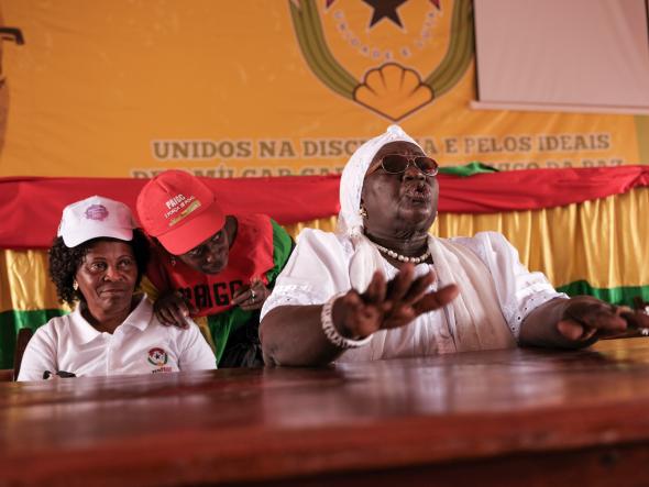 Bissau, Guinea Bissau (March 8, 2019) – Bilony Nhama (left, white shirt) is the Secretary General for the Women’s Democratic Union for the PAIGC party. She sits next to Teodora Gomes (far right), who is a hero of the country’s independence war. Here in Guinea Bissau, the women gather for an event on International Women’s Day, two days before legislative elections where a new law required that 36 % of candidates be women. Image credit Ricci Shryock.