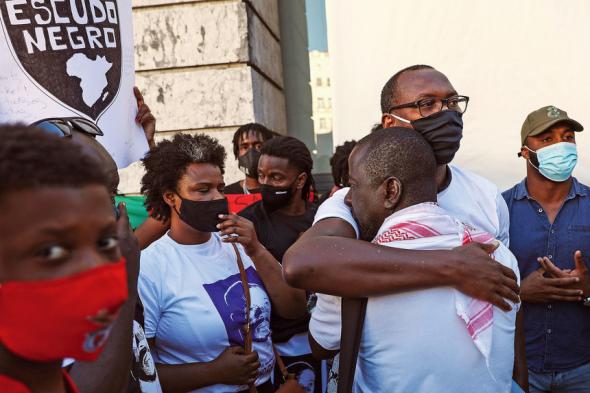 Mamadou Ba - de óculos e com uma máscara preta - dirigente da associação SOS RACISMO. 