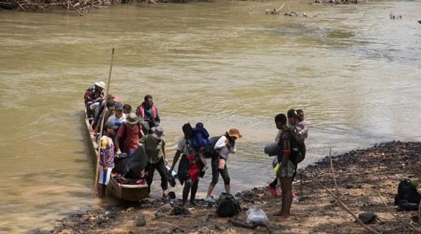 Migrantes atravessam em canoas o rio até ao campo de Bajo Chiquito, no Panamá (ACNUR)