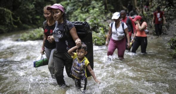 Migrantes cruzam um rio no Darién (Ivan Valencia  AP)