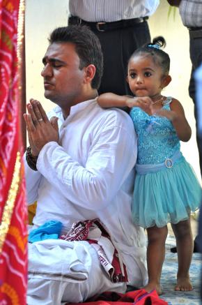 Nitin, sacerdote do templo de Maputo, conduzindo sentado as cerimónias de aniversário do templo, a 8 de Maio, com a filha Nandini sempre por perto